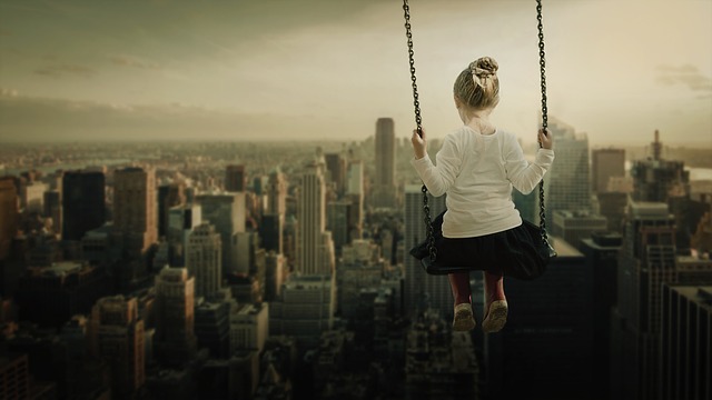 A girl on a swing overlooking a city